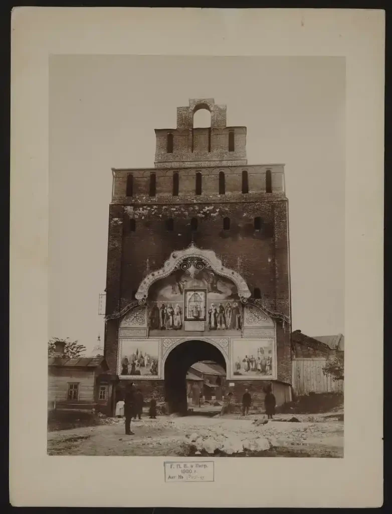 Пятницкие ворота, 1930 г., фотография из открытых источников. Пятницкие ворота, 1930 г., фотография из открытых источников. Если увеличить фрагмент в арке ворот, виден фрагмент дома 2 по улице Пушкина, фото 1930 года, то есть еще до его капитальной перестройки. Кованного крыльца там не видно, зато полукруглые окна угадываются.