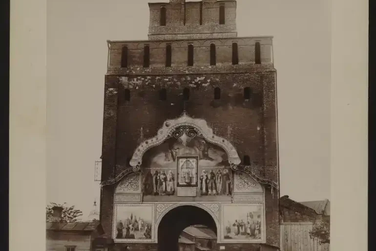 Пятницкие ворота, 1930 г., фотография из открытых источников. Пятницкие ворота, 1930 г., фотография из открытых источников. Если увеличить фрагмент в арке ворот, виден фрагмент дома 2 по улице Пушкина, фото 1930 года, то есть еще до его капитальной перестройки. Кованного крыльца там не видно, зато полукруглые окна угадываются.