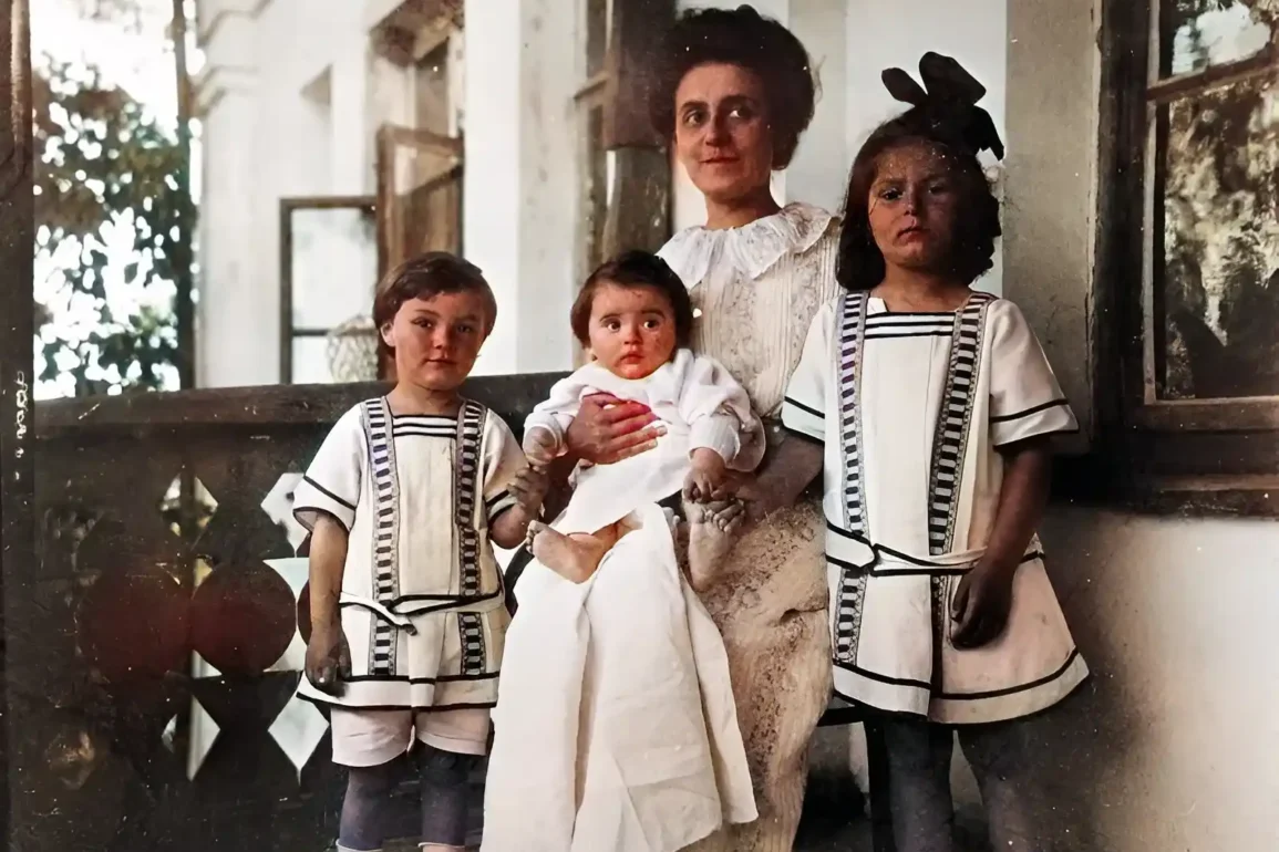 Т. Ф. Шлёцер-Скрябина с детьми (слева направо) Юлианом, Мариной, Ариадной. 1911 год, имение Образцово-Карпово Серпуховского уезда (сейчас - Б. Образцово, г. Ступино). Колоризированная и улучшенная версия черно-белой фотографии из "Википедии", см. также А. Н. Скрябин в пространствах культуры ХХ века. — М.: Композитор, 2009. — 368 с. — ISBN 5-85285-313-5. С. 173; https://scriabin.museum-online.moscow/entity/OBJECT/22449.